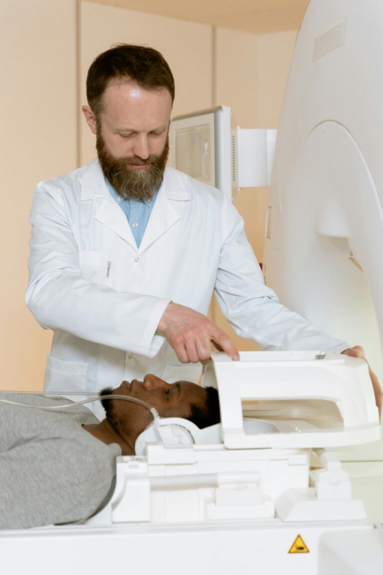 Patient undergoing MRI scan with doctor present in medical facility.